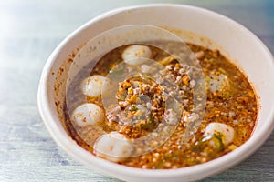 Closeup Spicy Tom Yum pork noodles with soup which contains fish balls, chilly pasted and lime juice. This noodles is a hot spicy