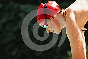 Closeup sportive woman, swimmer in cap and googles getting ready to start of swim at open public pool, outdoors