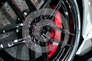 closeup of sports car alloy rim with red brake caliper