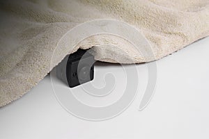 Closeup spy camera under cloth on white background