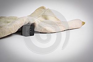 Closeup spy camera under cloth on white background