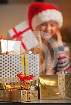 Closeup on stack of christmas present boxes and teenage girl in background