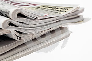 Closeup of stack of newspapers. Assortment of folded newspapers isolated on white. Breaking news, journalism, power of the media,