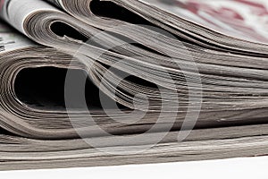 Closeup of stack of newspapers. Assortment of folded newspapers on white. Breaking news, journalism, power of the media,