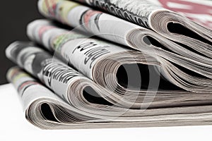 Closeup of stack of newspapers. Assortment of folded newspapers on white. Breaking news, journalism, power of the media,