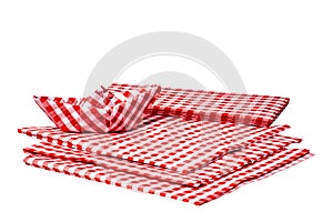 Closeup of a stack of red checked paper napkins and a folded paper ship isolated on a white background. Clipping path. Macro.