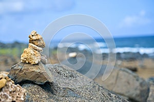 Closeup of stacked rocks on a beach with a blurry background