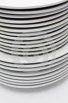 Closeup of stacked white plates isolated on white