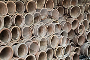 Closeup of stacks of old used weathered terra cotta flower pots in gardening shed