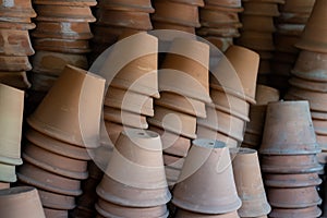 Closeup of stacks of old used weathered terra cotta flower pots in gardening shed