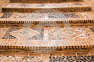 Closeup of the staircase of the old city, paved with a stone in the form of a picture. Mediterranean architecture in Spain