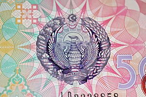 Closeup of state emblem with mythical bird Huma on Uzbekistan 500 Sum currency banknote issued 1999