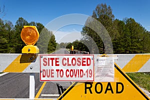 Closeup of state orders and warning signs on state campground roadblock during COVID-19 closures