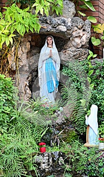 Statue of Our lady of grace virgin Mary view with natural background in the rock cave at Thailand. selective focus.