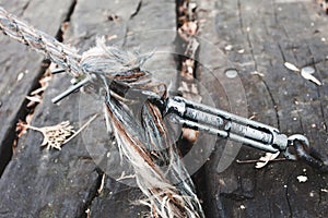 Closeup of steel cable with hook and rope on wooden pedestrian bridge