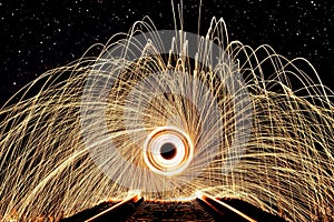 Closeup of a steel wool texture with circular patterns against a dark background.