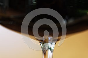 A closeup of a stem of a wine glass filled with red wine