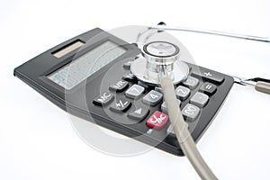 Closeup of stethoscope and calculator on table