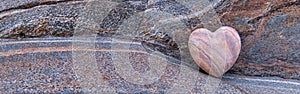 Closeup of a stone-shaped heart against a natural stone background