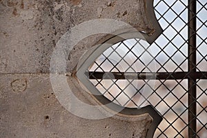 Closeup of a stone wall with a fenced window in  an abstract shape photo
