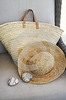 Closeup of straw hat and purse in chair