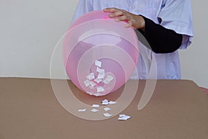Science experiment about static electricty from balloon and pieces of paper. photo