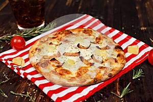 Closeup studio shot hot oven baked tasty delicious Italian homemade ham pineapple traditional Hawaiian bread crust round pizza