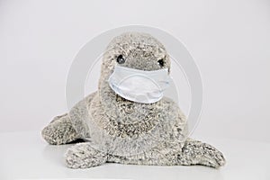 Closeup of a stuffed toy seal with a facemask isolated on a white background