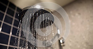 Closeup of stylish chrome shower spraying water