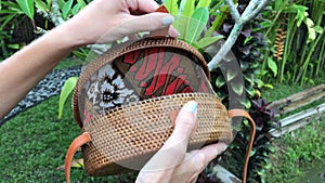 Closeup of stylish handmade rattan handbag on a tropical background. Bali island.