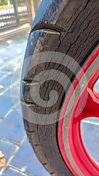 Closeup of the surface of an old motorcycle tire with a damaged