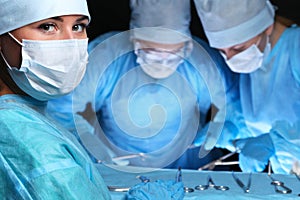 Closeup of surgeons performing operation. Focus on female nurse. Medicine, surgery and emergency help concepts