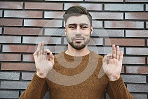 Closeup surprised man in eyeglasses looking at camera and open mouth on brick background