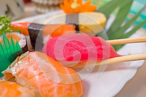 Closeup sushi with chopsticks In white plate . Japanese style Food