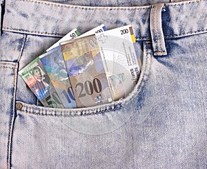 Closeup of the swiss notes in the jeans pocket.