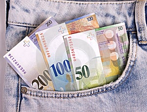 Closeup of the swiss notes in the jeans pocket.