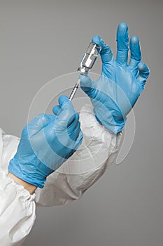Closeup of syringe in doctor or nurse's hand from a vial to vaccinate into patients for immunization.