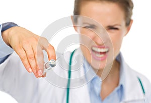 Closeup on syringe in hands of frightening doctor