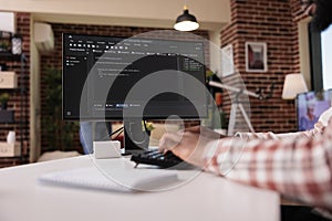 Closeup of system developer writing code on personal computer typing algorithm on keyboard