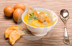 Closeup table setting with serving of traditional fanesca soup and eggs working as decor photo