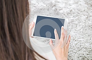 Closeup tablet computer on asian woman hand on blurred gray carpet floor textured background with copy space