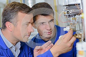 Closeup teacher and student looking at boiler controls