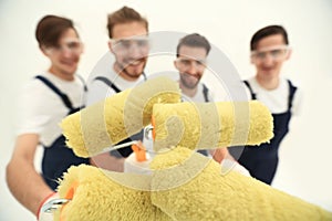 Closeup.a team of builders with paint rollers.i