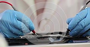 Closeup of technician man hand measuring electrical voltage of computer mainboard using digital multimeter