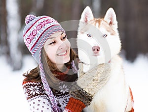 Closeup teen girl embracing cute dog in winter par