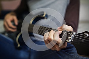 Closeup of teenage boy playing guitar