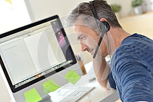 Closeup of telemarketing worker with headset photo