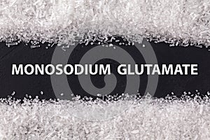 Closeup texture umami on dark background with text Monosodium glutamate . Sodium salt MSG, E621 used as flavor enhancer. Food photo