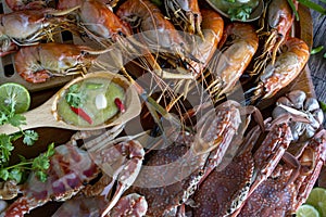 Closeup Thai Seafood platter lunch in Thailand Summer vacation. Whole crab and prawns bbq served with Thai seafood dipping spicy