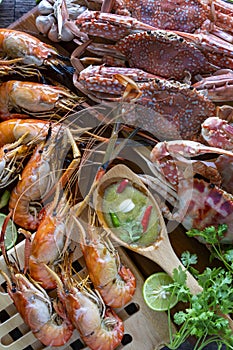 Closeup Thai Seafood platter lunch in Thailand Summer vacation. Whole crab and prawns bbq served with Thai seafood dipping spicy